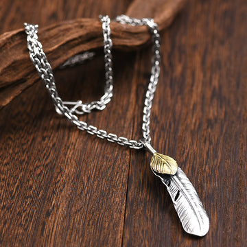 colir cu pandantiv in forma de pana argintie cu detalii aurii