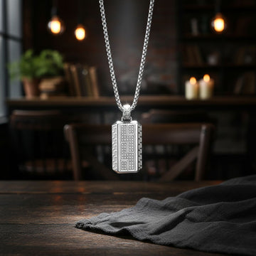 Un colier modern pentru bărbați, cu un lanț din oțel inoxidabil de tip box chain, lung de 60 cm, și un medalion rectangular masiv (4x2 cm). Medalionul este decorat cu cristale de zirconiu dispuse într-un model geometric, adăugând strălucire.